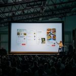 A man giving presentation in hall on the projector screen