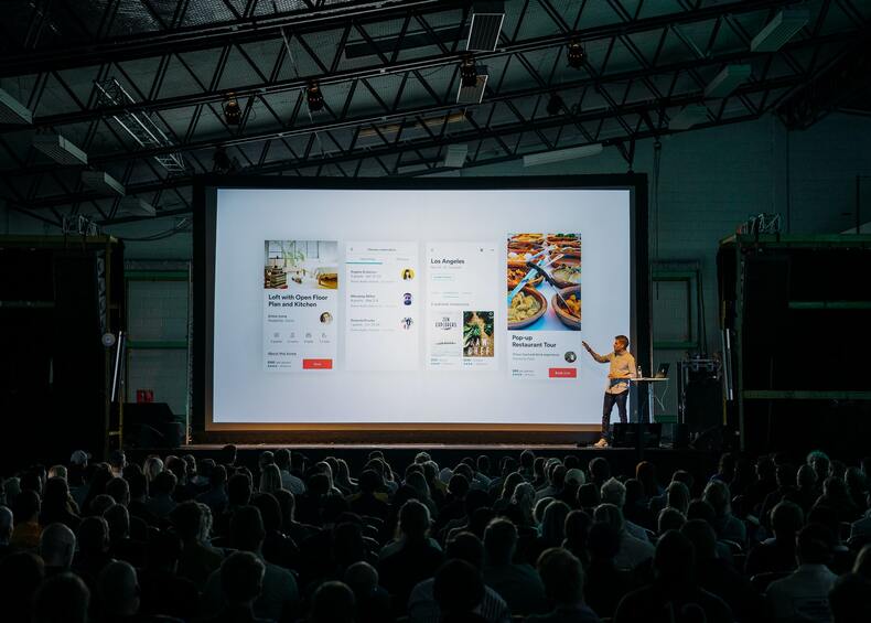 A man giving presentation in hall on the projector screen