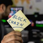 Man Showing a paper with writing 'Block chain'